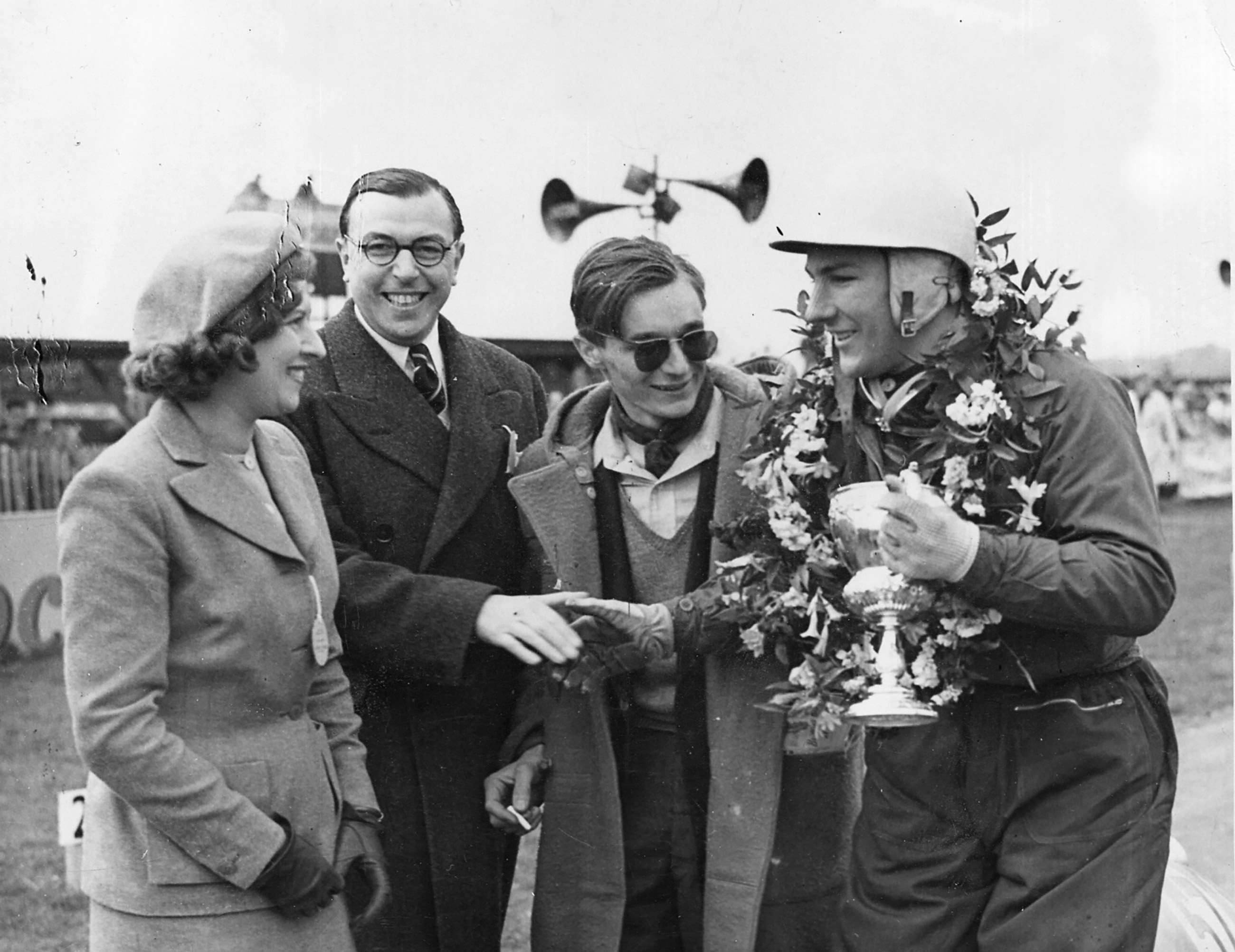 Dan Glover and his wife (left) with Stirling Moss (far right) and Stirling’s business manager and Secretary of the 500 Club at the time, Ken Gregory…Stirling having just won the 1951 edition of the  Glover Trophy in his 500cc Formula 3 Kieft…