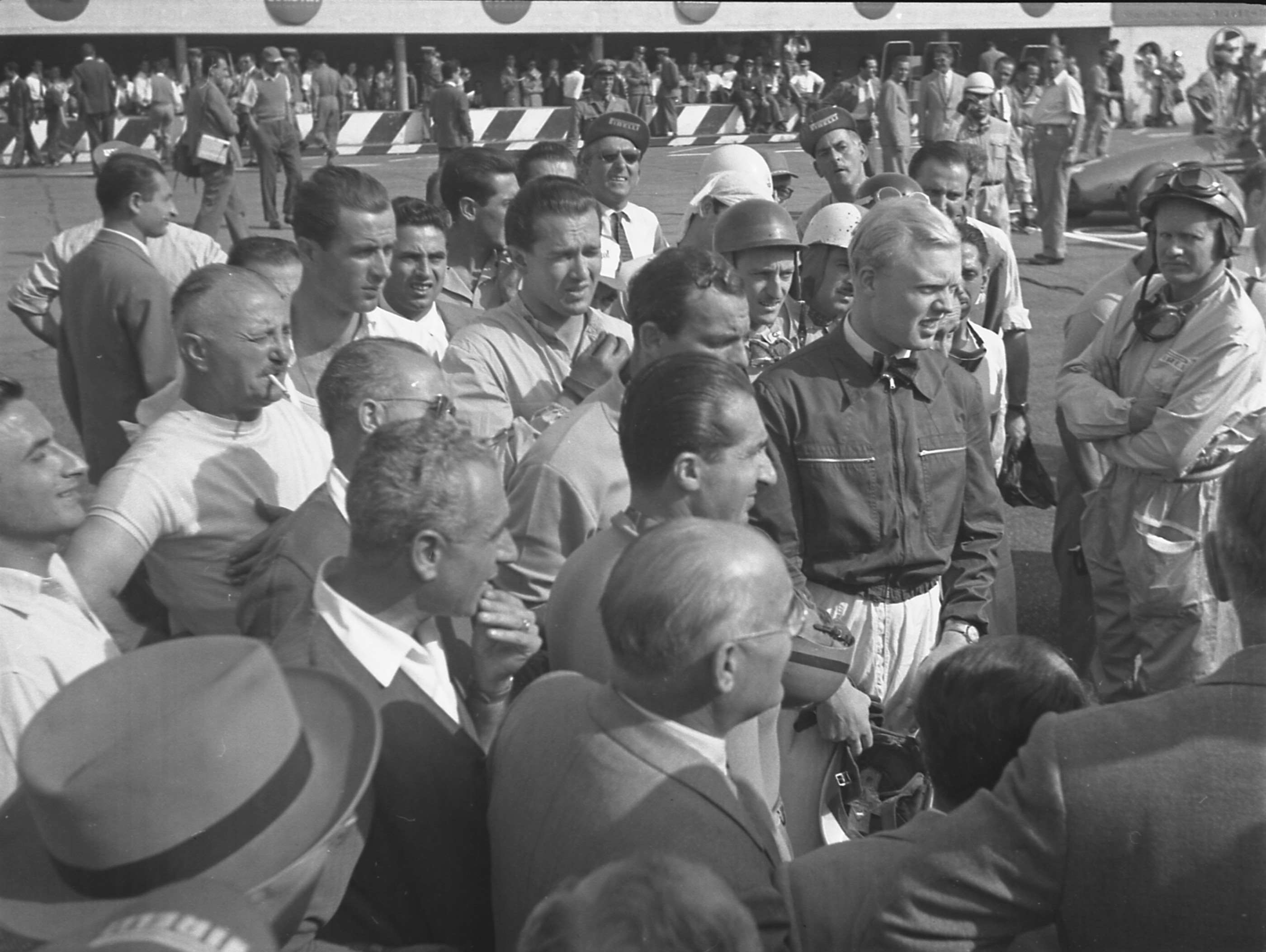 On-grid driver-briefing time before the 1953 Italian Grand Prix at Monza - de Graffenried in helmet, complete with two pairs of goggles, right.