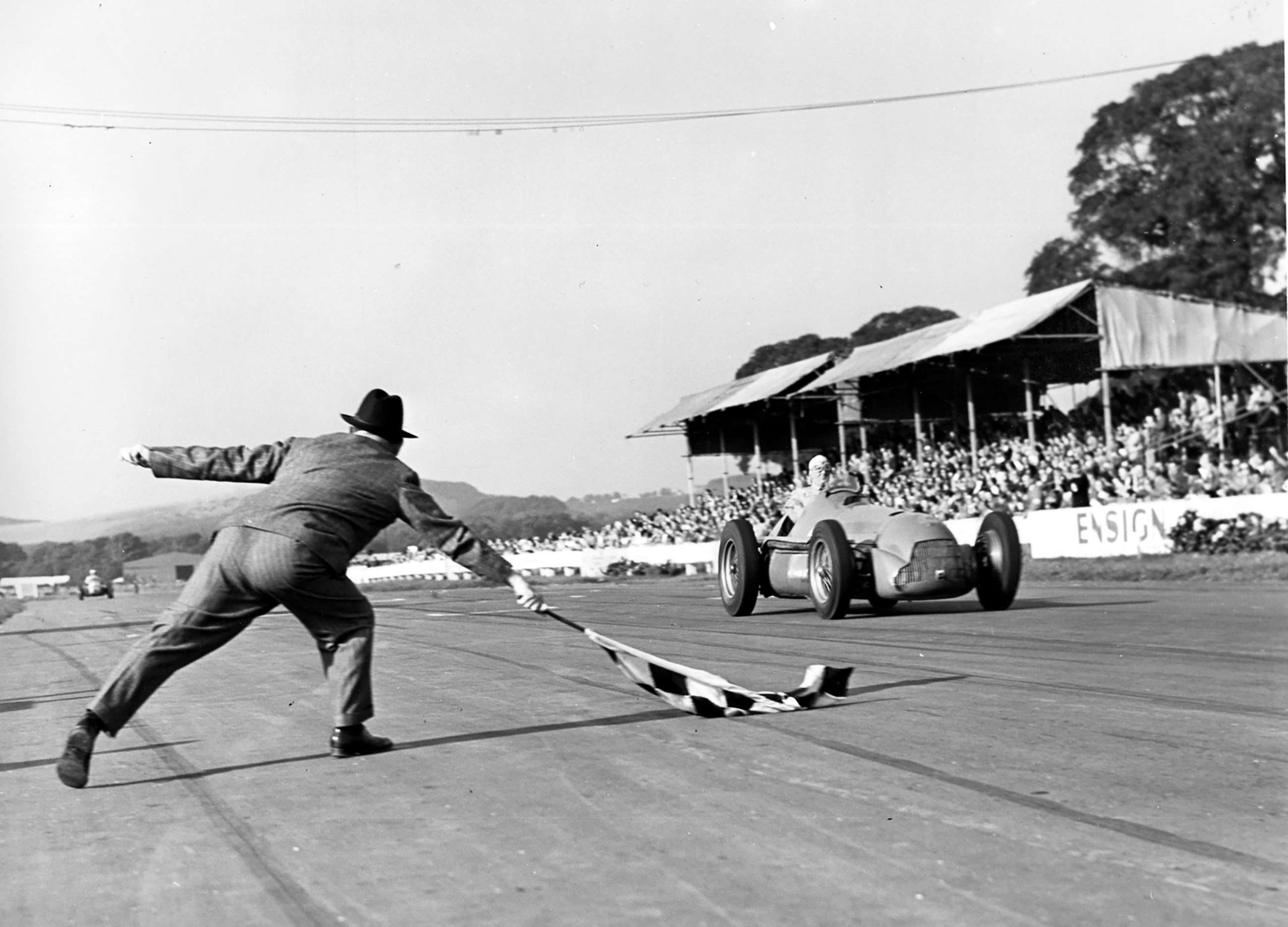 John Morgan of the BARC flags home winner of the 1951 Goodwood ‘Daily Graphic’ Trophy - 1950 World Champion ‘Nino’ Farina - Alfa Romeo 158