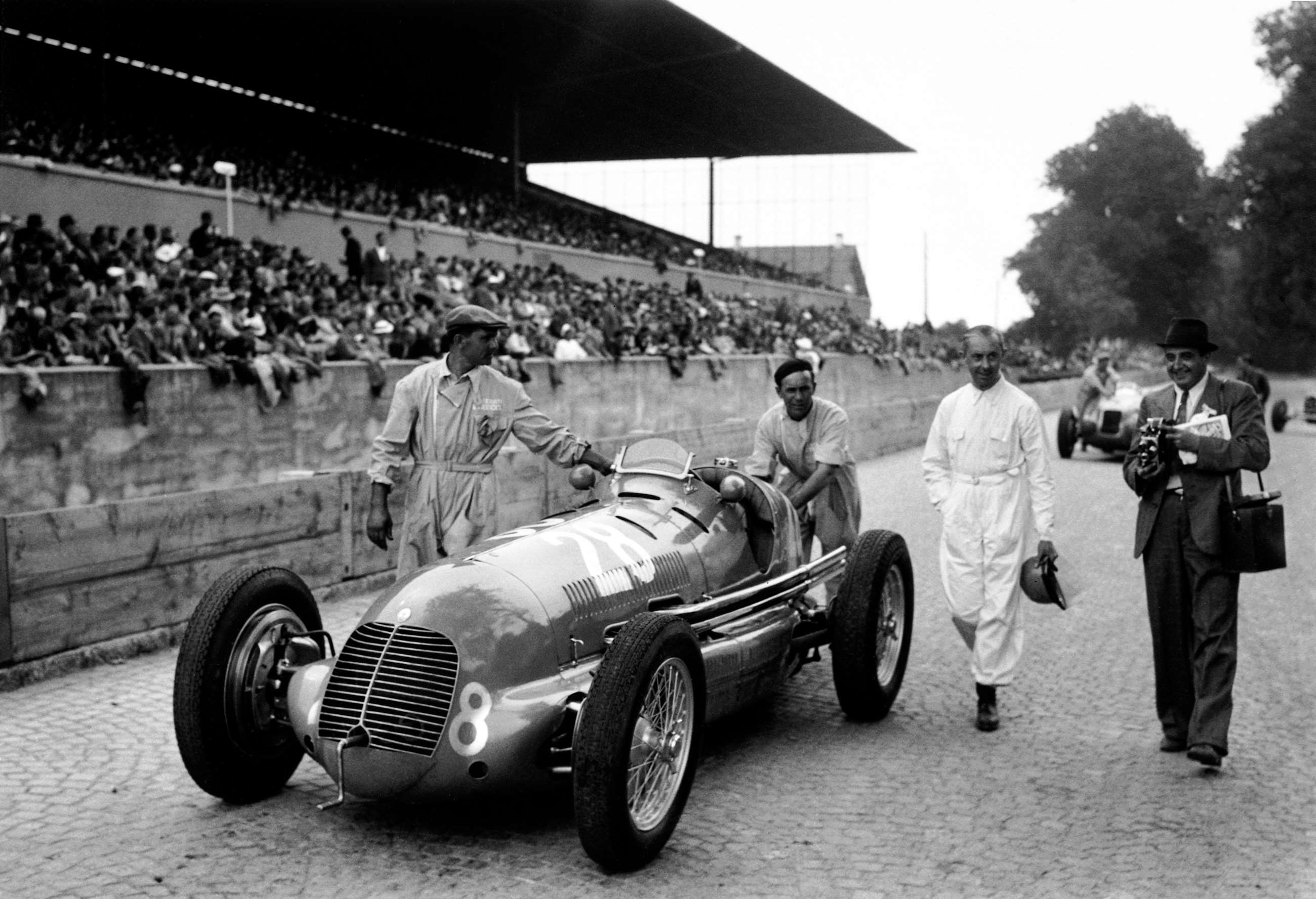 Rene Dreyfus walks with his mechanics alongside his 8CTF, Bremgarten, Switzerland, 20th August 1939.