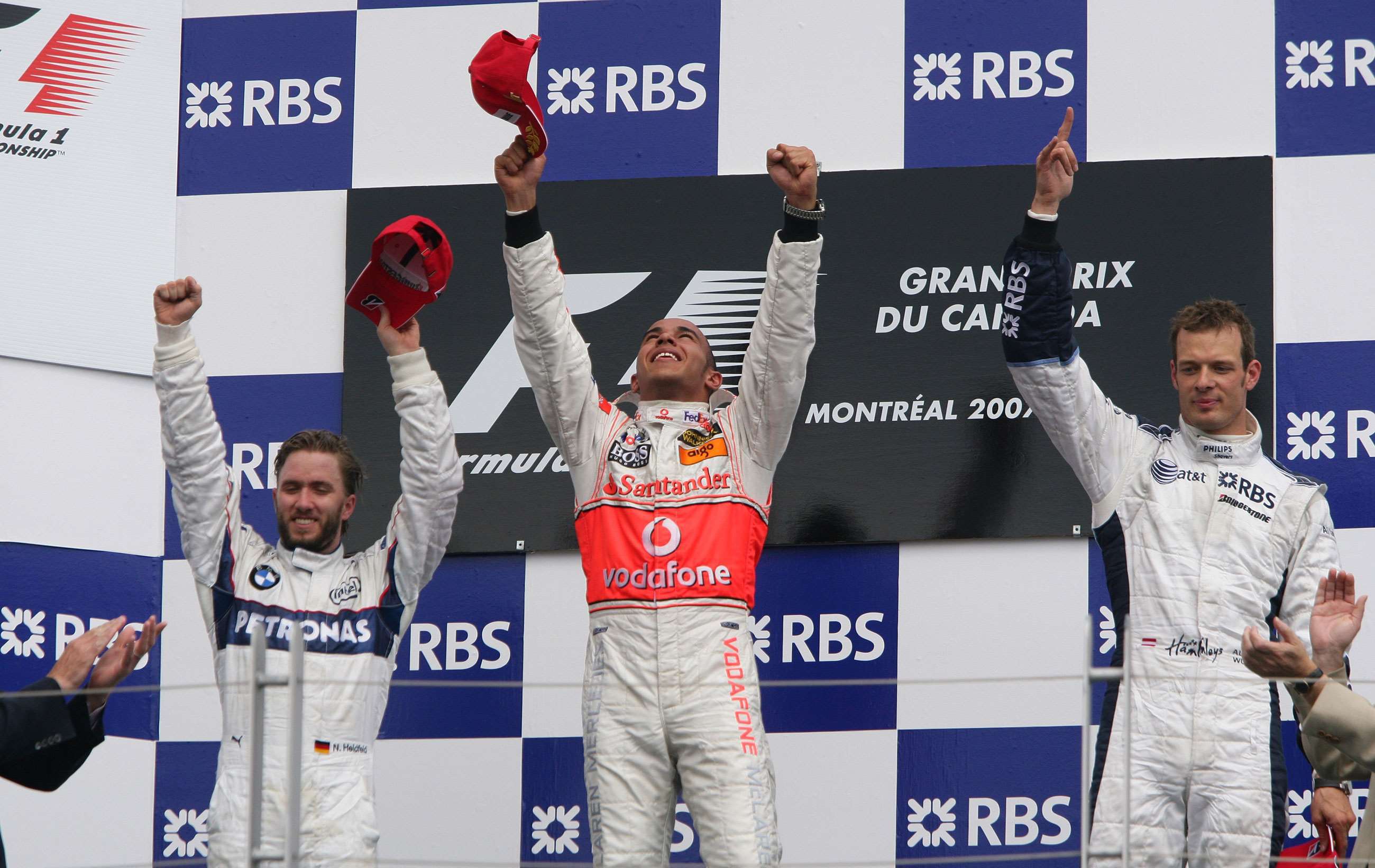 Hamilton celebrating his first win on the podium in Canada, 2007. To his right stands Nick Heidfeld, to his left Alex Wurz. 